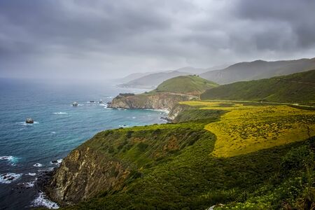California coastal land and seascape on iconic Highway 1 with bridge in distance
