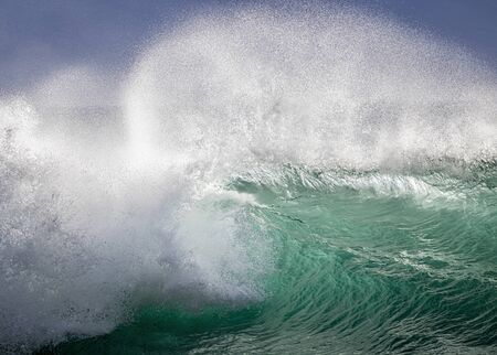 Big breaking wave with glowing green water and big white spray and foam filling the frame.  Image taken in Hawaii.の写真素材