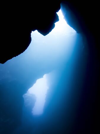 Light shines through underwater lava caves in Hawaii.の写真素材