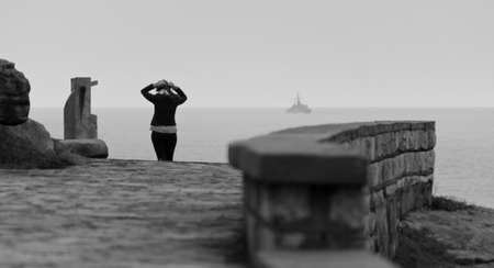 woman walking along the coast, sea bottom with boat