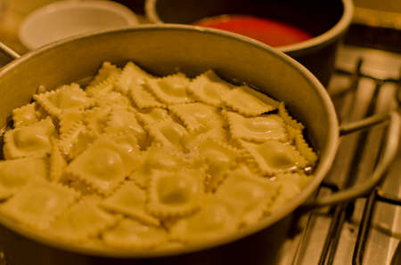 preparing ravioli with red sauceの写真素材