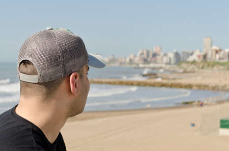 young man walking on the beach on a sunny day