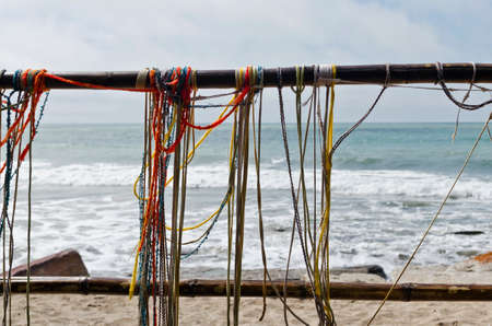 colored threads hanging near the beachの写真素材