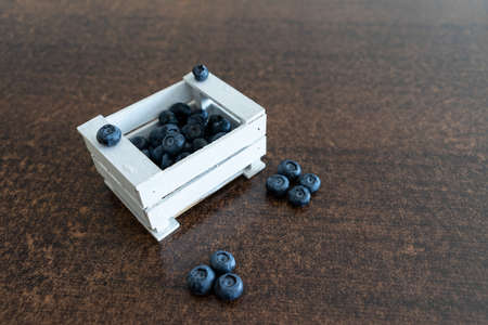 Fresh blueberries in white box on wooden background.の写真素材