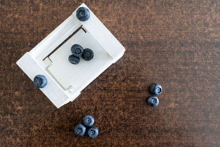 Fresh blueberries in white box on wooden background. top view.の写真素材