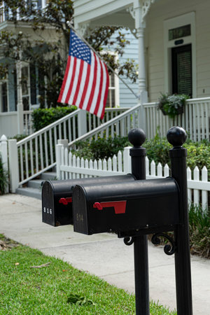 Celebration, Orlando, Florida, USA, May 15, 2021: black mailboxes with traditional house and american flag backgroundのeditorial素材