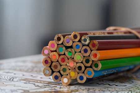 Colored pencils on a wooden table. Select focus.