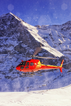 Red helicopter landing at swiss ski resort near Jungfrau mountainのeditorial素材