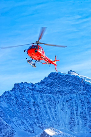 Red helicopter at swiss alps near Jungfrau mountainの写真素材