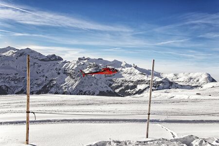 Landing of red helicopter at swiss alpine highland resortの写真素材