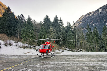 Red helicopter at swiss alpine heliport in winter
