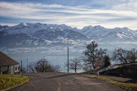Swiss lake view near Thun with a view of Alps mountains and a small ship in winterの写真素材