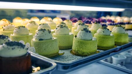 Assorted chesecakes on the bakery storefront with blurred backgroundの写真素材