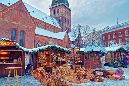 Traditional Christmas market stall with straw basket souvenirs displayed for sale in the Old Town of Riga, Latviaの写真素材