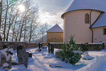 Snow-covered medieval cemetery near Gruyere castle on a sunny winter day, Switzerlandのeditorial素材