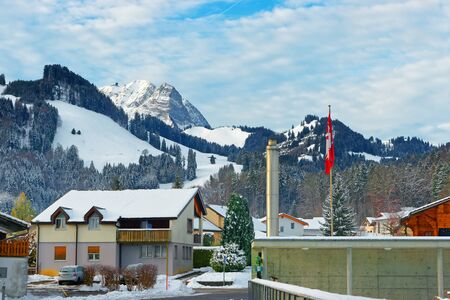Buildings of the town of Gruyeres standing out against the background of snow-covered swiss mountains. District of Gruyere in the canton of Fribourg, Switzerlandのeditorial素材
