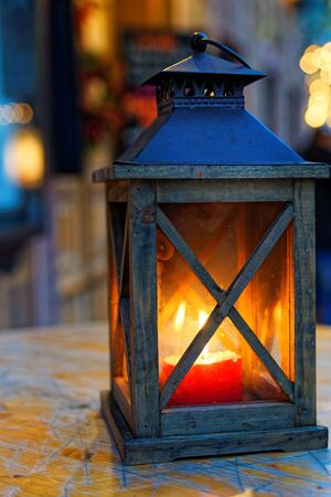 Burning lantern on wooden surface and blurred background. Garmisch-Partenkirchen, Bavaria, Germanyの写真素材