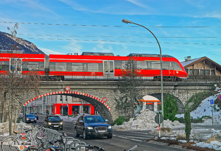 High-speed train crossing a bridge in Garmisch-Partenkirchen on a sunny winter day. Bavaria, Germany