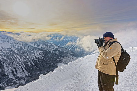 Man taking photos in Kasprowy Wierch in Zakopane in Tatras. Zakopane is a town in Poland in Tatra Mountains. Kasprowy Wierch is a mountain in Zakopane and is the most popular ski area in Polandの写真素材