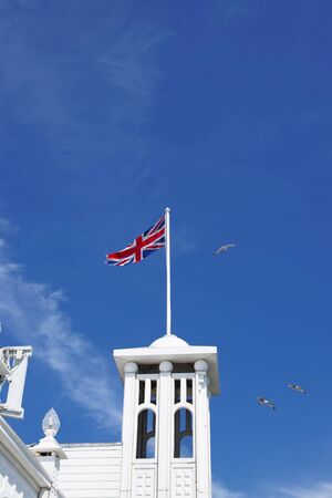Tower with a US flag in Brighton Pier in East Sussex in the UK. It is also called Brighton Marine Palace and Pier, or Palace Pier.の写真素材