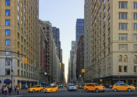Crossroad on 6th avenue in Midtown Manhattan, New York, USA. Road leading to Central Park South. Heavy traffic on the road, especially taxi cars. And many tourists passing by.のeditorial素材