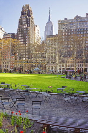 Tables and Chairs at Green Lawn and Skyscrapers in Bryant Park in Midtown Manhattan, New York, USA. Tourists relaxingのeditorial素材