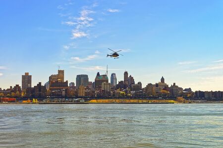 Helicopter over East River, New York, USA. Skyscrapers of Brooklyn on the background.の写真素材