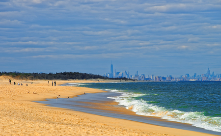 Atlantic Ocean shore at Sandy Hook with view of NYC. Sandy Hook is in New Jersey, USA. Tourists on the shoreのeditorial素材