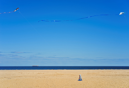 Sandy Hook, USA - April 26, 2015: Child and Paper Kites above Atlantic Ocean shore at Sandy Hook with a view of NYC. Sandy Hook is in New Jersey, USA.のeditorial素材
