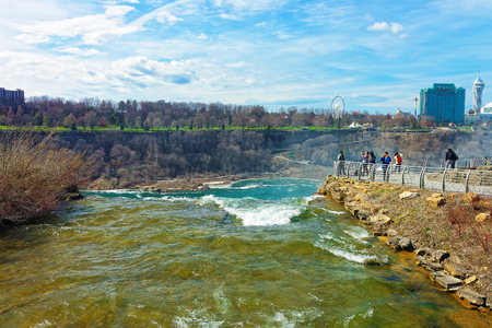 Niagara Falls in US and View on Ontario in Canada near Niagara River. Niagara River is a border between the United States of America and Canada. Tourists nearbyのeditorial素材