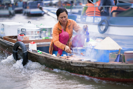 Can Tho, Vietnam - February 28, 2016: Woman cooking food for sale in the floating market in Can Tho in Vietnam.の写真素材