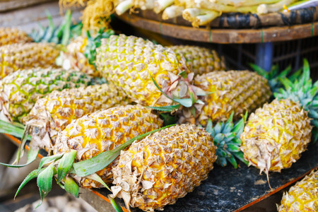 Asian street farmer market selling fresh ananas in Hoi An, Vietnam. Yellow and green colors.の写真素材