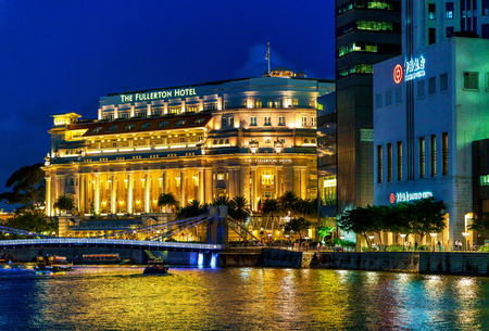 Singapore, Singapore - February 29, 2016: Fullerton hotel building at Marina Bay in Singapore at night. It is illuminated with light and reflected in the water.のeditorial素材