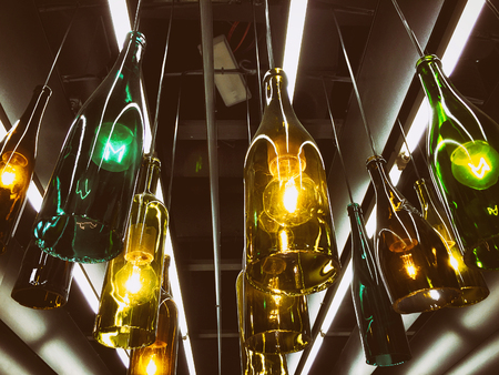 Beautiful retro light lamp decoration made of the empty wine bottles. Tonedの写真素材