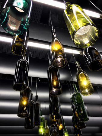 Magnificent retro light lamps decoration made of empty wine bottles. Tonedの写真素材