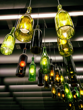 Beautiful retro light lamp decor made of the wine bottles. Tonedの写真素材