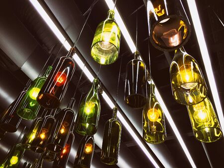 Magnificent retro light lamps decoration made of wine bottles. Toned