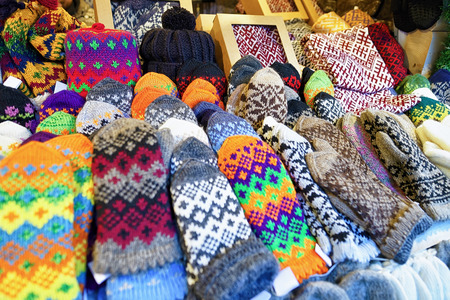 Colorful and ornamental mittens, gloves, socks and hats at one of the stalls during Christmas Market in Riga, Latvia. People can buy there warm clothes, traditional souvenirs, goods. Selective focusの写真素材