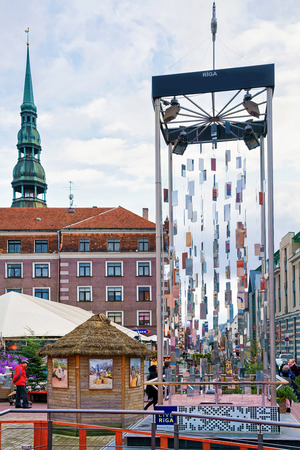 Riga, Latvia - December 26, 2015: Artistic Christmas tree made from mirrors and the dome of Saint Peter church in the background at leisure park Egle in the old town of Riga, Latvia.のeditorial素材