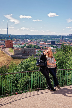 Vilnius, Lithuania - May 26, 2016: Women making selfie with Gedimino Tower on the hill and the Lower Castle down the hill in Vilnius in Lithuania. The Tower is also called as Upper Castle.のeditorial素材