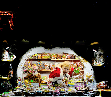 Riga, Latvia - December 24, 2015: Woman selling one of the most traditional sweet treats which are gingerbreads pictured at the Christmas Market in Riga in Latvia.のeditorial素材