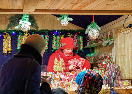 Vilnius, Lithuania - December 27, 2015: Seller and buyers at Stall with traditional colorful and festive candies at the Christmas Market in Vilnius, Lithuania.のeditorial素材