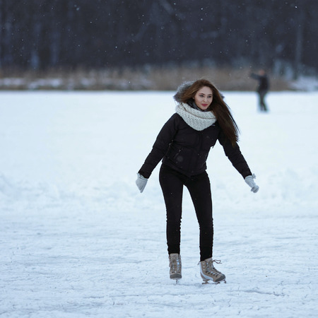 Trakai, Lithuania - January 17, 2016: Young girl ice skates at the winter rink covered with snow, Trakai in Lithuania.の写真素材