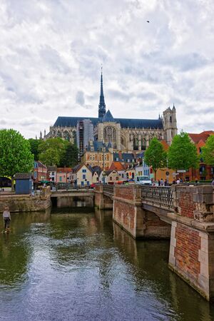Amiens, France - May 9, 2012: Amiens Cathedral of Notre Dame and traditional houses on La place du Don Square at the embankment of Somme canal, Picardy, France. People on the backgroundのeditorial素材