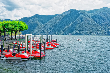 Lugano, Switzerland - August 26, 2013: Catamarans at the promenade of the luxurious resort in Lugano on Lake Lugano and Alps mountains in Ticino canton of Switzerland.のeditorial素材