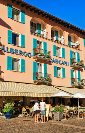 Ascona, Switzerland - August 23, 2016: Cafes and restaurants at the luxurious resort in Ascona on Lake Maggiore in Ticino canton of Switzerland. People on the background.のeditorial素材