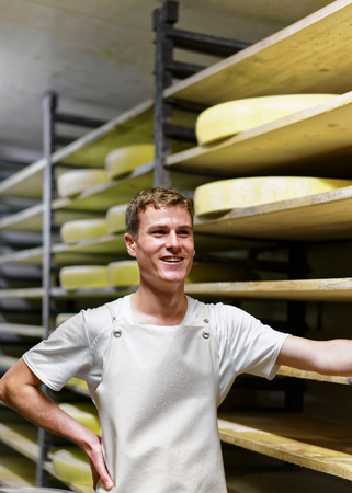 Evillers, France - August 31, 2016: Cheesemaker at storehouse of Comte Cheese in ripening cellar at...