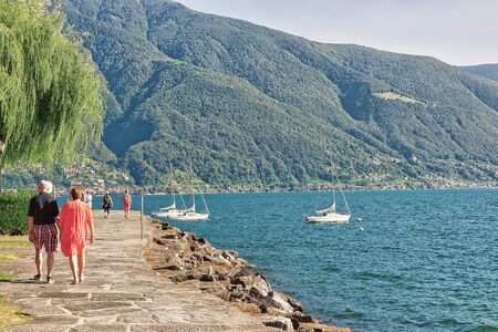 Ascona, Switzerland - August 23, 2016: Couple passing by at the promenade at the luxurious resort in Ascona on Lake Maggiore in Ticino canton, Switzerland.のeditorial素材