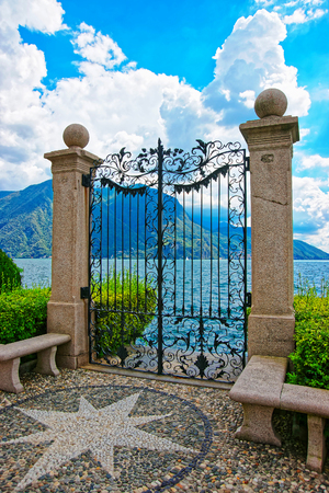 Lugano, Switzerland - August 26, 2013: Gate at the botanical garden at the promenade of the luxurious resort in Lugano on Lake Lugano and Alps mountains in Ticino canton of Switzerland.の写真素材