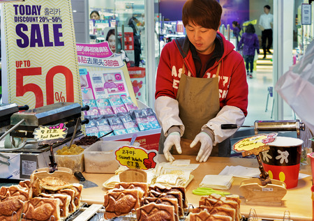Seoul, South Korea - March 14, 2016: Seller of buns with red beans in Myeongdong open street market in Seoul, South Koreaのeditorial素材